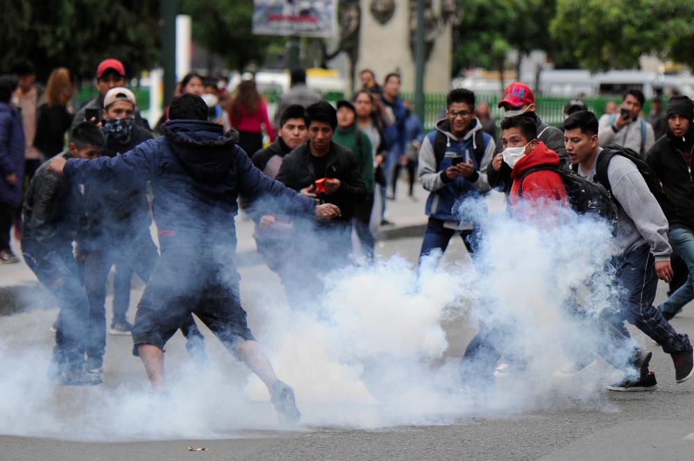 Supporters of Bolivian ex-President Evo Morales and locals discontented with the political situation clash with riot police during a protest in La Paz on Nov 13. — AFP