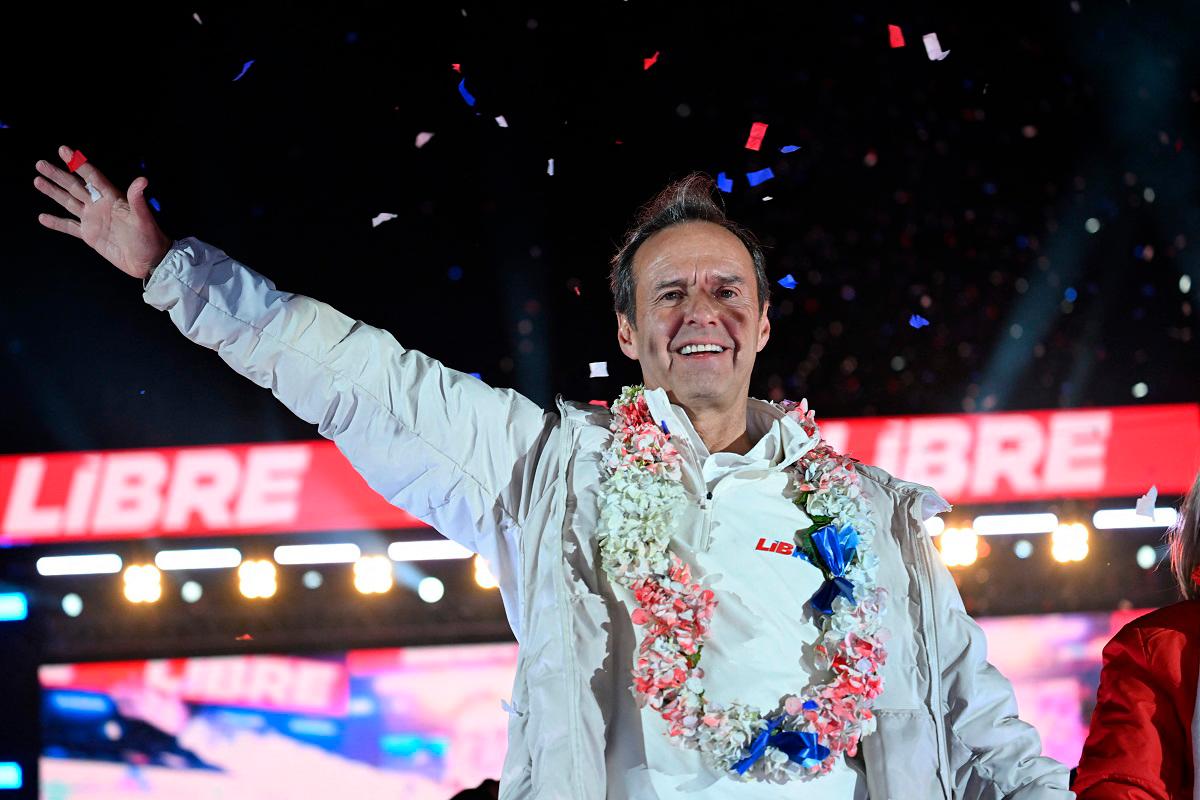 Former Bolivian president and presidential candidate for the “Alianza Libre” (Free Alliance) coalition, Jorge “Tuto” Quiroga Ramirez, greets supporters during his final campaign rally in La Paz on August 13, 2025. Bolivia will hold presidential election on August 17, 2025. - MARTIN BERNETTI / AFP