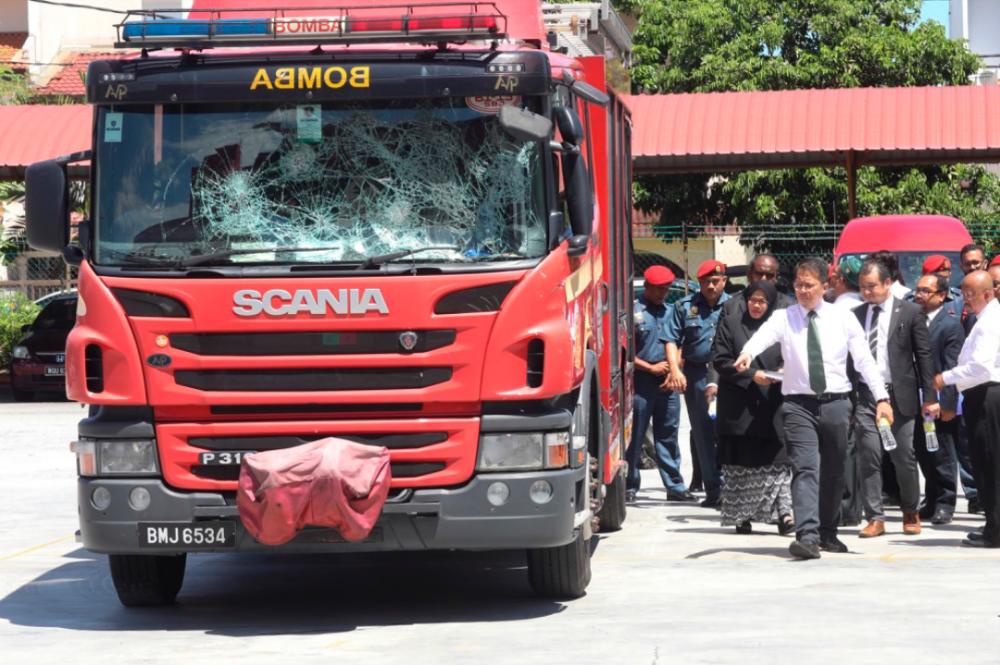 Coroner Rofiah Mohamad takes a look at one the fire engines that was damaged during the Seafield temple riots last year. — Sunpix by Asyraf Rasid