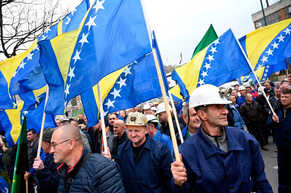 Bosnian coal miners wave flags as they march towards government building in Sarajevo, on March 27, 2024, to protest against the deterioration of their working conditions/AFPPix
