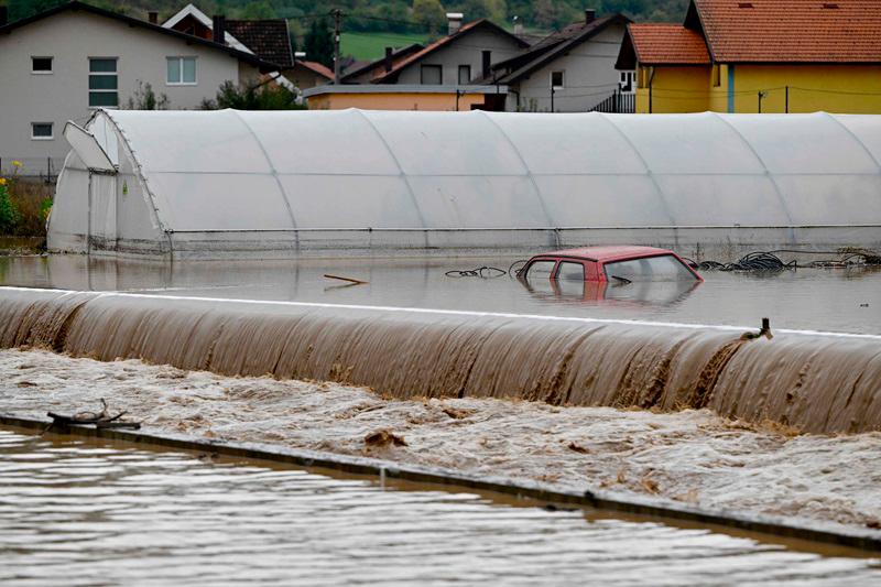 A vehicle is partially submerged following heavy rains in the town of Kiseljak, about twenty kilometres west of Sarajevo on October 4, 2024. Several towns in central Bosnia were severely flooded October 4, after heavy rains. Houses, cars and gardens were under water in Kiseljak, an AFP journalist noted, while more serious damage is feared in the town of Jablanica, which is still inaccessible. - Elvis BARUKCIC / AFPpix