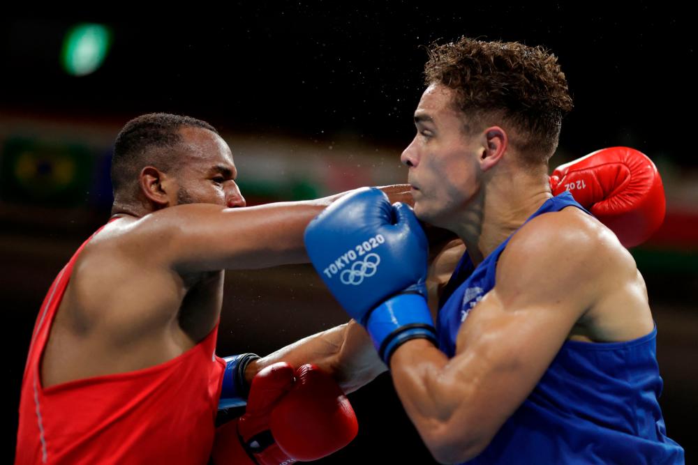 Morocco’s Youness Baalla (red) and New Zealand’s David Nyika fight during their men’s heavy (81-91kg) preliminaries round of 16 boxing match during the Tokyo 2020 Olympic Games at the Kokugikan Arena in Tokyo on July 27, 2021. -AFP