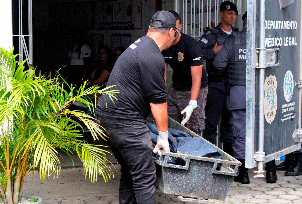 Criminal experts carry the body of a victim of a shooting at a school in Aracruz, Espirito Santo State, Brazil, on November 25, 2022/AFPPix