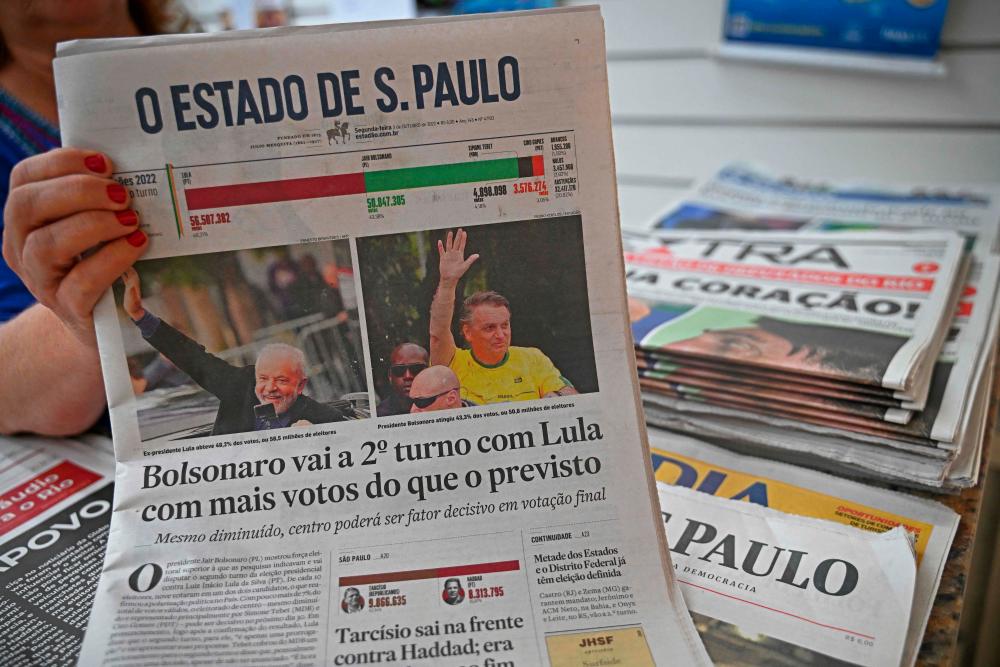 A vendor holds up the front page of one of Brazil’s National newspapers the day after the Presidential elections in Rio de Janeiro, Brazil on October 3, 2022. AFPPIX