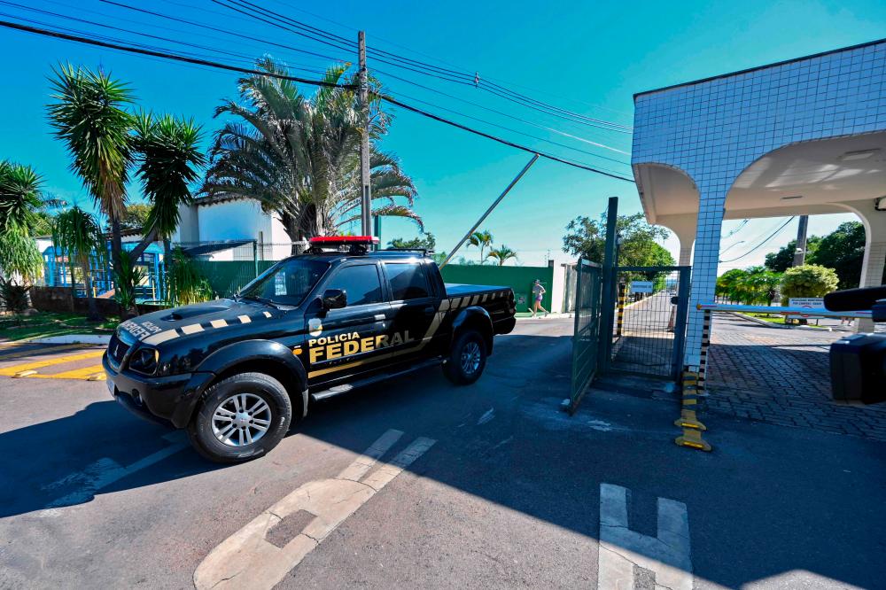 A vehicle of the Federal Police leaves the condominium where Brazilian ex-president Jair Bolsonaro lives, after allegedly searching his home as part of an investigation into allegations of falsifying COVID-19 vaccination certificates, in Brasilia on May 3, 2023. AFPPIX