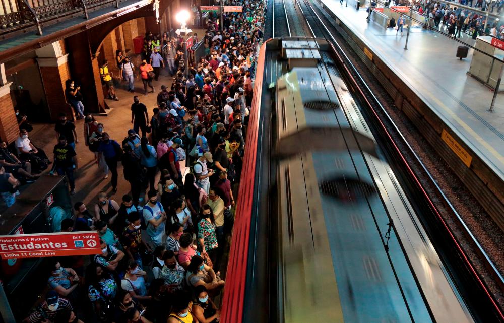 Passengers gather to board a train at Luz station in central Sao Paulo, Brazil, on March 5, 2021, amid the Covid-19 pandemic. - AFP