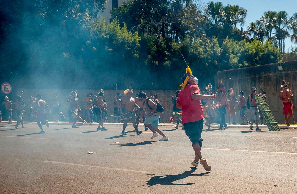 Handout picture released by CIMI (Indigenous Missionary Council) showing indigenous people clashing with the police during a protest against a bill that would change the regulations establishing protected indigenous lands, in Brasilia on June 22, 2021. – AFP