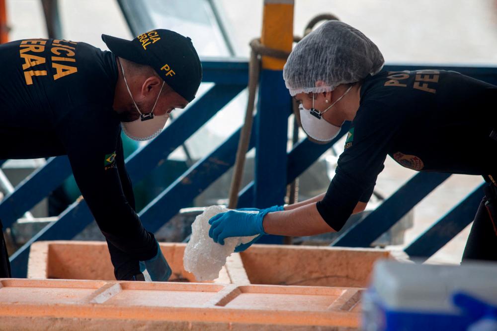A Federal Police experts examine a boat seized by the Task Force for the rescue of Indigenist Bruno Pereira and Journalist Dom Phillips at the port of the city of Atalaia do Norte, Amazonas, Brazil/AFPPix