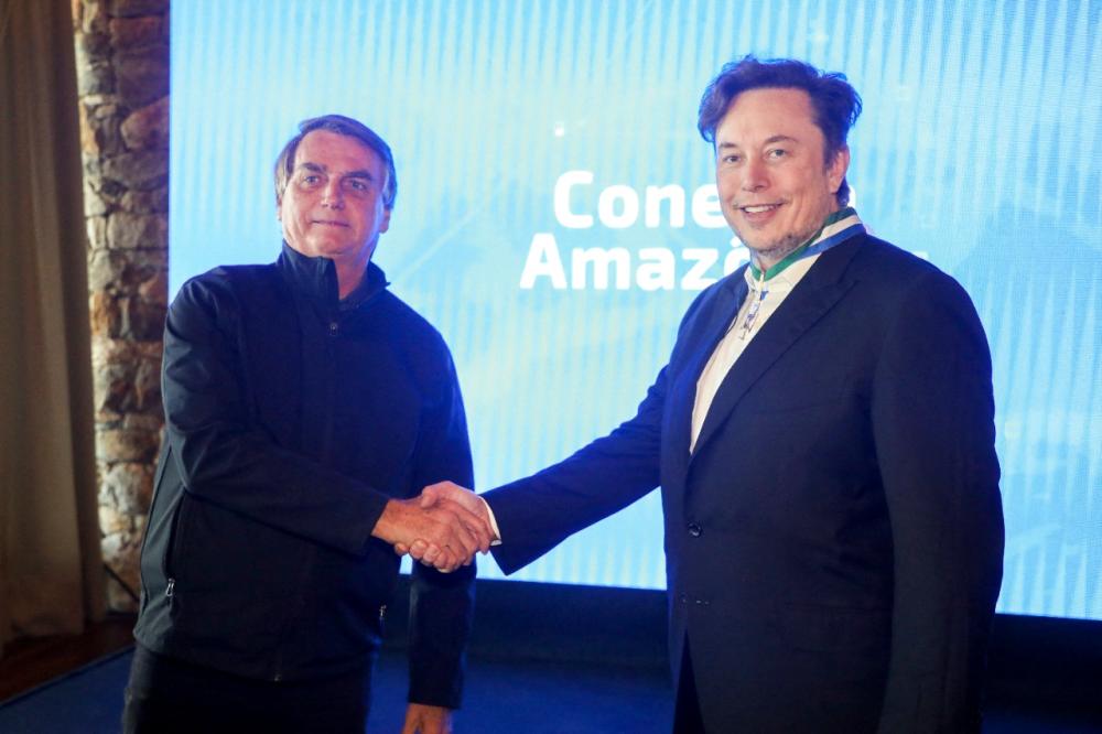 Brazil’s President Jair Bolsonaro (L) shakes hands with CEO, and chief engineer at SpaceX, Elon Musk, at the event Conecta Amazonia in Porto Feliz, Sao Paulo state, Brazil on May 20, 2022. AFPPIX