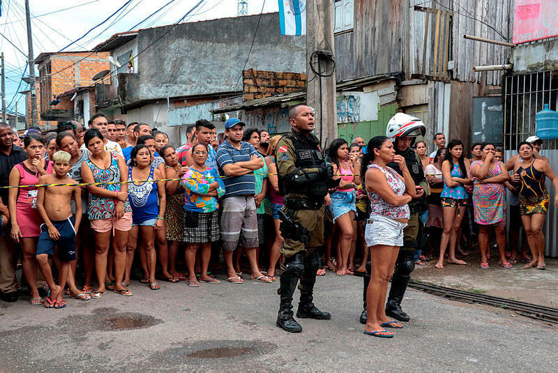 Residents gather outside a bar as forensic personnel and criminal police remove corpses after a shooting, in Belem, Para state, Brazil on May 19, 2019. — AFP