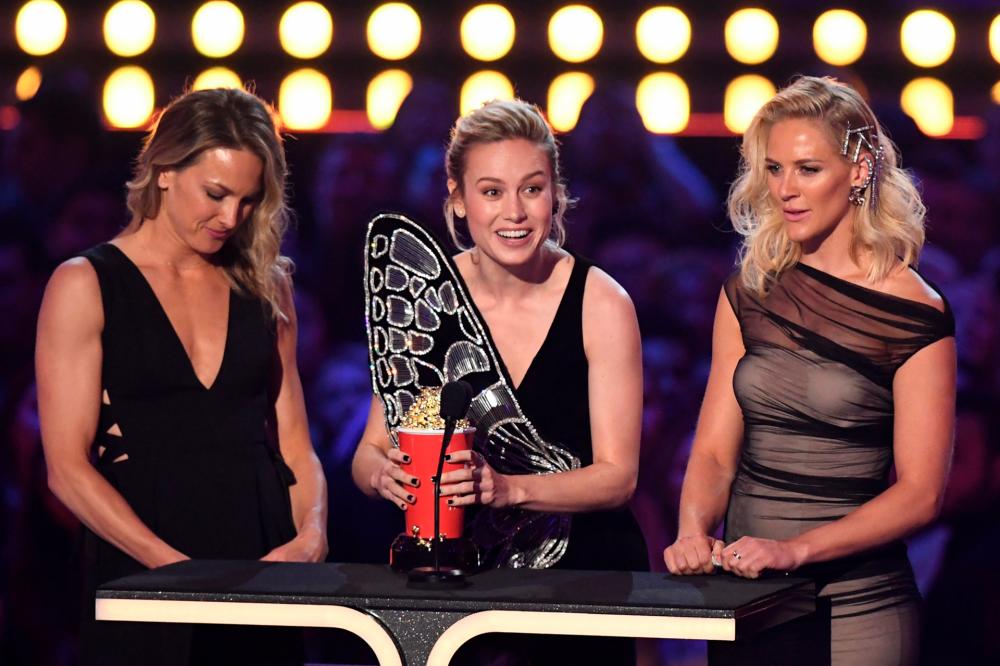 US actress Brie Larson, flanked by her stunt doubles Joanna Bennett and Renae Moneymaker, accepts the award for Best Fight for “Captain Marvel” during the 2019 MTV Movie &amp; TV Awards at the Barker Hangar in Santa Monica on June 15, 2019.