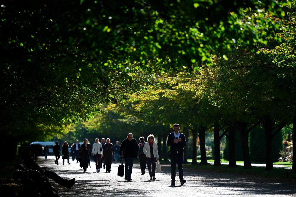 Pedestrians walk along a path during the Frieze Art Fair in Regents Park in London on October 13, 2021. AFPpix