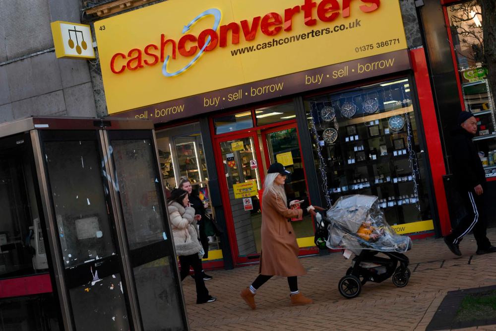 Pedestrians walk past a cash converters store in Grays, Essex, on January 18, 2023. AFPPIX