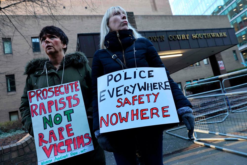 Protesters hold placards against the police outside Southwark Crown Court in London on February 6, 2023 during the two-day sentencing of serial rapist police officer David Carrick/AFPPix