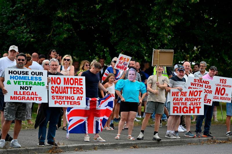 Protesters, including one wearing a mask of Prime Minister Keir Starmer, hold placards during a ‘Enough is Enough’ demonstration called by far-right activists near a hotel housing asylum seekers in Aldershot - AFPpix