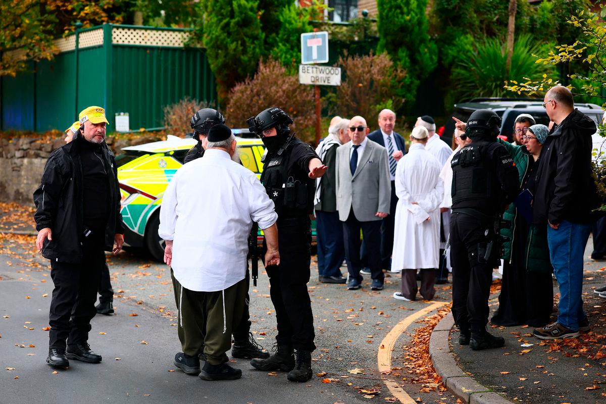 Armed police officers talk with members of the community near Heaton Park Hebrew Congregation synagogue in Crumpsall, north Manchester, on October 2, 2025, following an incident at the synagogue. (Photo by Paul Currie / AFP)