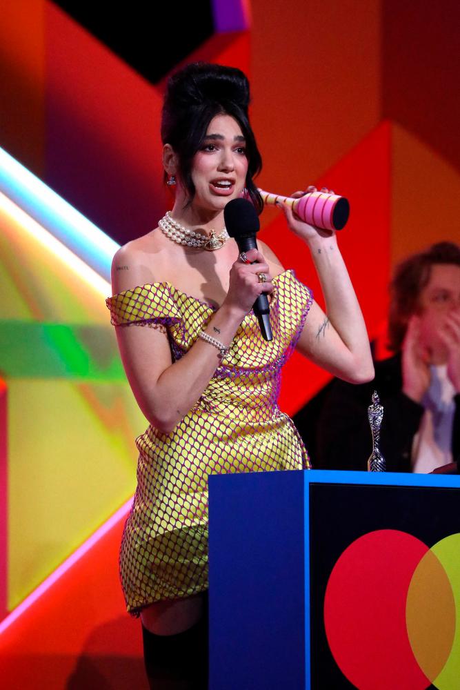 In a handout picture released by the Brit Awards English singer-songwriter Dua Lipa accepts her British Album award at the BRIT Awards 2021 in London on May 11, 2021. – AFP