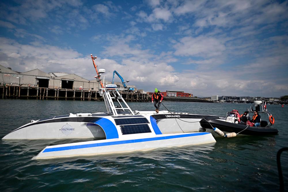 Engineers guide the Mayflower 400 autonomous trimaran towards Turnchapel Wharf following sea trail in Plymouth, south west England on April 27, 2021. The Mayflower 400, the world's first intelligent ship, bobs gently in a light swell as it stops its engines in Plymouth Bay, southwest England. –AFP