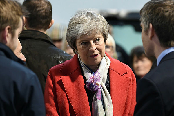 Britain’s Prime Minister Theresa May (C) meets with agricultural producers and business representatives as she tours the Royal Welsh Winter Fair at the Royal Welsh Showground in Builth Wells, Powys, in Mid Wales, on Nov 27, 2018. — AFP