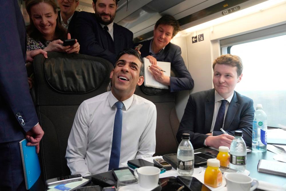 Britain’s Prime Minister Rishi Sunak (C) speaks to the press in the train during his travelling to France,on March 10, 2023 ahead of his meeting with French President. AFPPIX