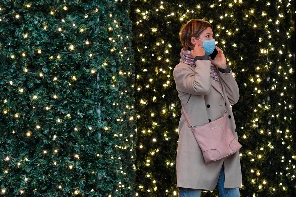 A woman walks past a Christmas light display at a department store in central London on Thursday. – AFPPIX
