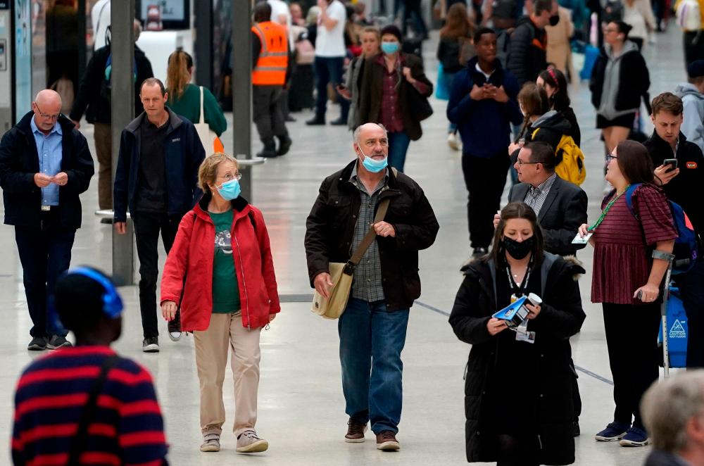 Commuters, some wearing face coverings to help prevent the spread of coronavirus, walk through Waterloo train station in central London on October 19, 2021. AFPpix
