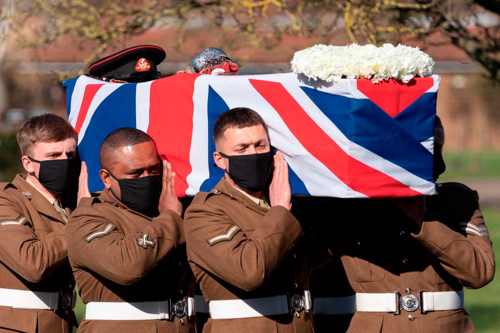 Soldiers from the British Army’s Yorkshire Regiment carry the coffin of Captain Tom Moore during his funeral service at Bedford Crematorium in Bedford, north of London on February 27, 2021. -AFP