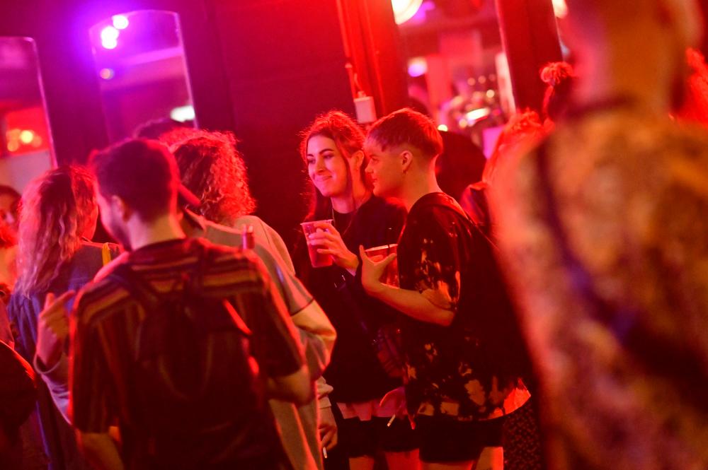 Revellers drink in the street outside the bars in the Soho area of London on July 4, 2020, as restrictions are further eased during the novel coronavirus Covid-19 pandemic. — AFP
