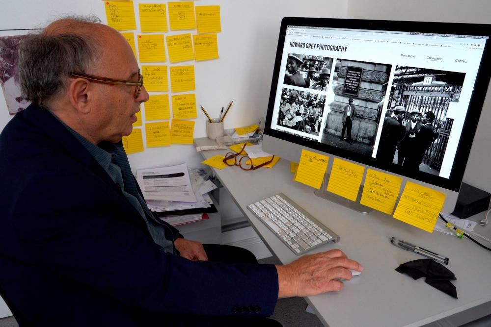 Photographer Howard Grey shows photographs on a computer in London on July 1, 2022. On the day the Windrush migrants arrived, a young London photographer named Howard Grey had an idea. AFPPIX