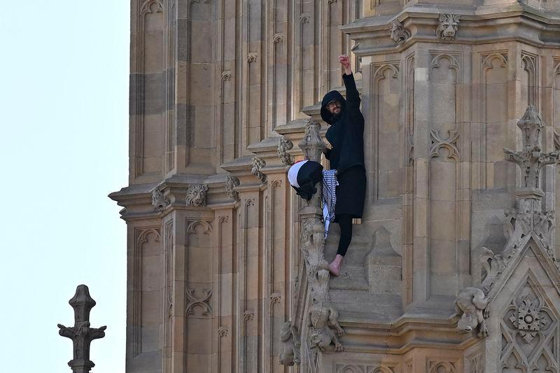 A protester holding a Palestinian flag gestures from the side of the Elizabeth Tower, commonly known by the name of the clock’s bell “Big Ben”. AFPpix