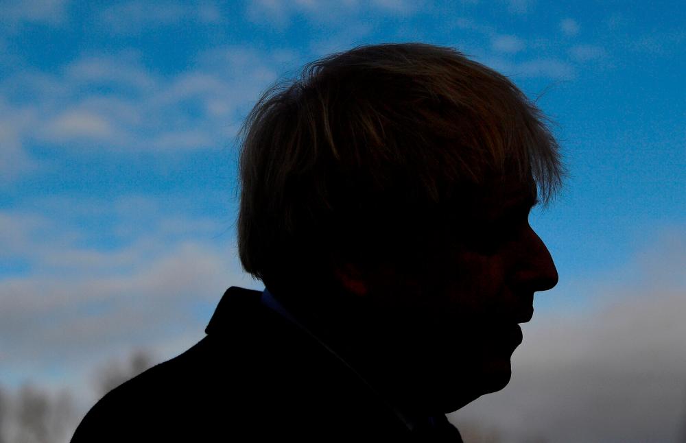 Britain's Prime Minister Boris Johnson speaks to members of the media during a football campaign event in Cheadle Hulme, north-west England on December 7, 2019. - AFP