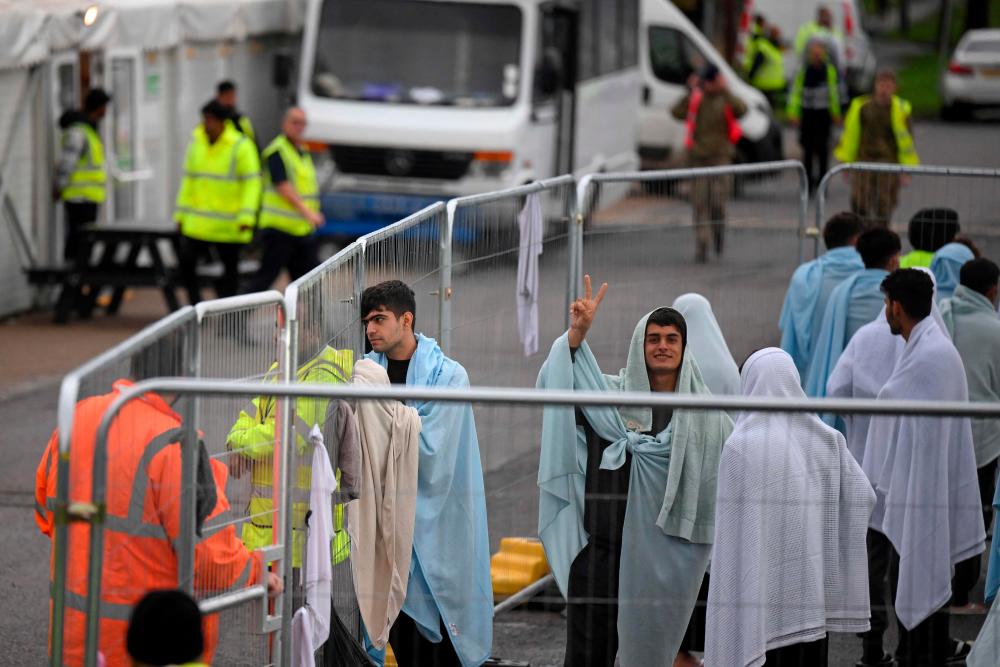 Detainees are seen wrapped in blankets inside the Manston short-term holding centre for migrants, near Ramsgate, south east England on November 3, 2022. AFPPIX