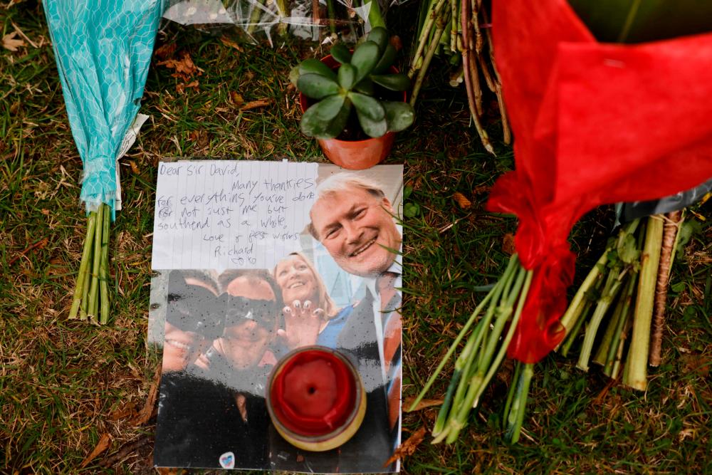 A photograph of Conservative British lawmaker David Amess is seen among the floral tributes left at the scene of the killing of Amess at Belfairs Methodist Church in Leigh-on-Sea, a district of Southend-on-Sea, in southeast England on October 16, 2021. The fatal stabbing of British lawmaker David Amess was a terrorist incident, police said Saturday, as MPs pressed for tougher security in the wake of the second killing of a UK politician while meeting constituents in just over five years. -AFP