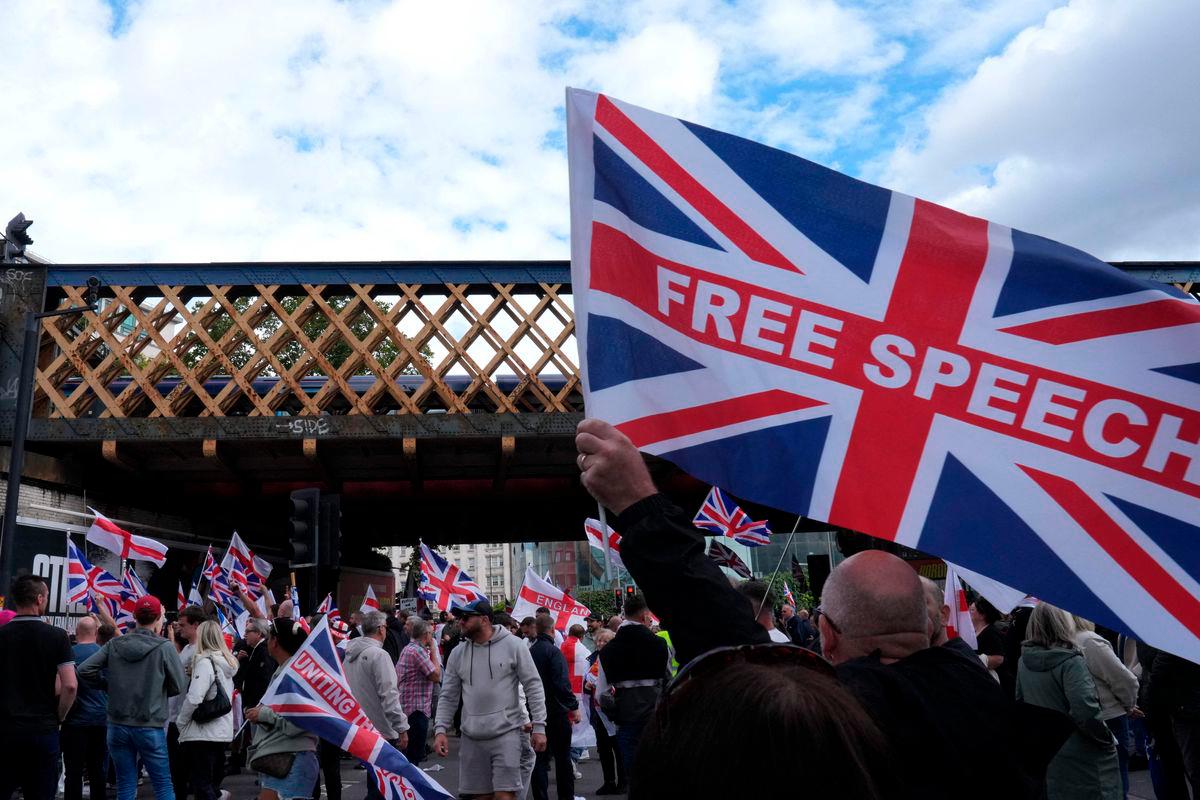 Supporters of British far-right activist Tommy Robinson whose real name is Stephen Yaxley-Lennon, walk through central London waving flags during a ‘Free speech’ march, on September 13, 2025. (Photo by CARLOS JASSO / AFP)