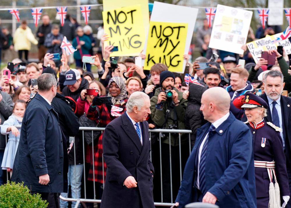 Demonstrators hold placards reading Not My King as Britain's King Charles III meets well-wishers upon arriving at the Church of Christ the Cornerstone in Milton Keynes, north of London on February 16, 2023, to attend a reception to mark Milton Keynes' new status as a city. AFPPIX