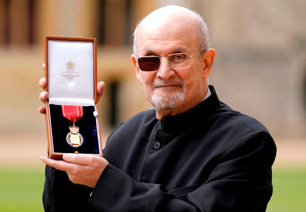 British author Salman Rushdie poses with their medal after being appointed as a Member of the Order of the Companions of Honour (CH) during an investiture ceremony at Windsor Castle on May 23, 2023. AFPPIX