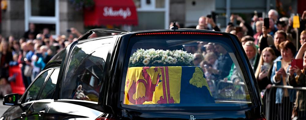 Members of the public pay their respects as they hearse carrying the coffin of Queen Elizabeth II, draped in the Royal Standard of Scotland, is driven through Ballater, on September 11, 2022. AFPPIX