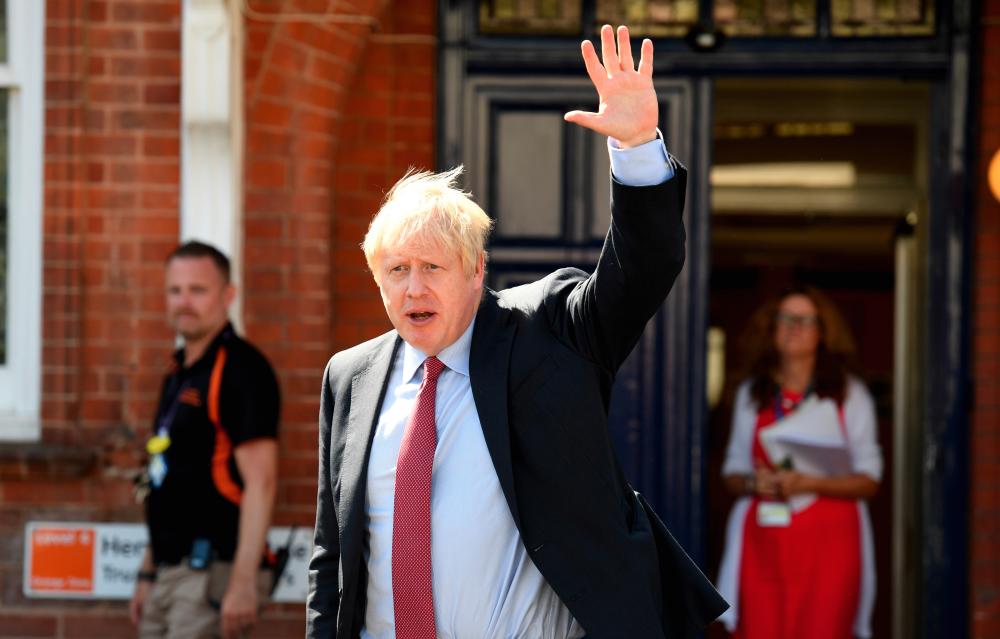 British Prime Minister Boris Johnson waves as he departs following a visit to Torbay Hospital in Torquay, Britain Aug 23, 2019. - Reuters