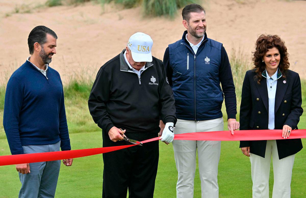US President Donald Trump (2L), flanked by his sons Eric Trump (2R) and Donald Trump Jr. (L), along with Trump International Golf Links Executive Vice President Sarah Malone cuts the ribbon on the first tee to officially open the Trump International Golf Links course in Balmedie, Aberdeenshire.
