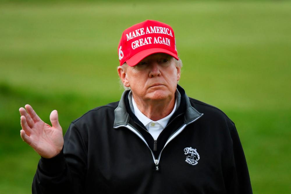 Former US President Donald Trump waves as he plays golf at the Trump Turnberry Golf Courses, in Turnberry on the west coast of Scotland on May 2, 2023, during the second day of his first visit to the country since losing the Presidency. - AFPPIX