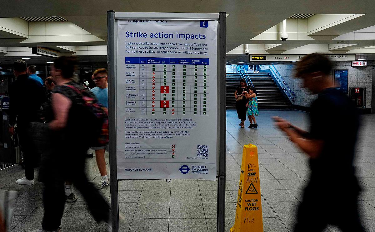 An information board warns commuters and rail users of the impact to London Underground services during a planned strike action by members of the Railway workers’ union RMT, at Victoria Station in London on September 7, 2025. - CARLOS JASSO / AFP