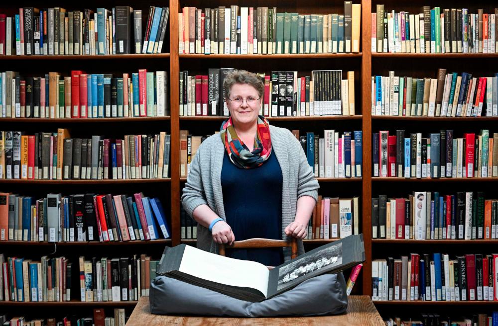 College Archivist Frieda Midgley poses for a portrait in the library at Newnham College, part of the University of Cambridge, on March 21, 2024, in Cambridge, eastern England. - AFPPIX