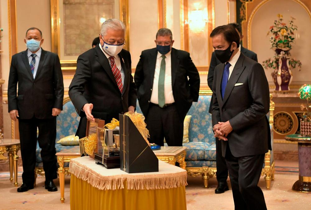 BANDAR SERI BEGAWAN, Feb 15 - Sultan of Brunei Sultan Hassanal Bolkiah (right) accepts a gift presented by Prime Minister Datuk Seri Ismail Sabri Yaakob (second, left) at Istana Nurul Iman. BERNAMApix