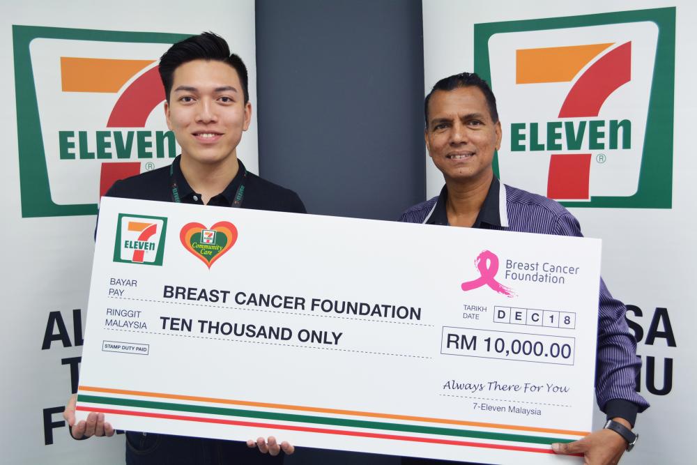 Communications and Creative Manager (Marketing) of 7-Eleven Malaysia, Lawrence Ng (left), presenting a mock cheque to Razlan.