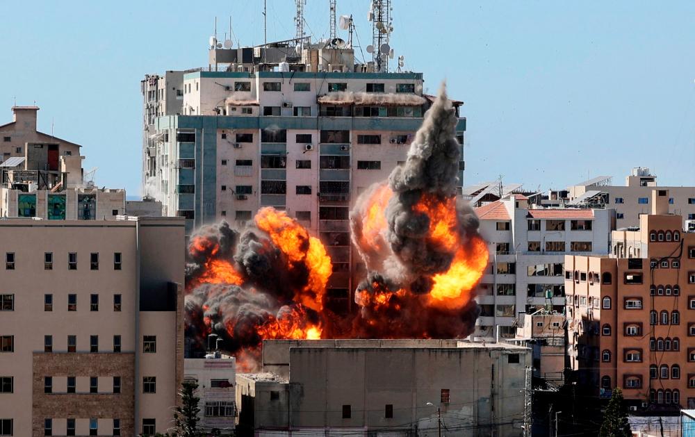 A ball of fire erupts from the Jala Tower as it is destroyed in an Israeli airstrike in Gaza city. — AFP