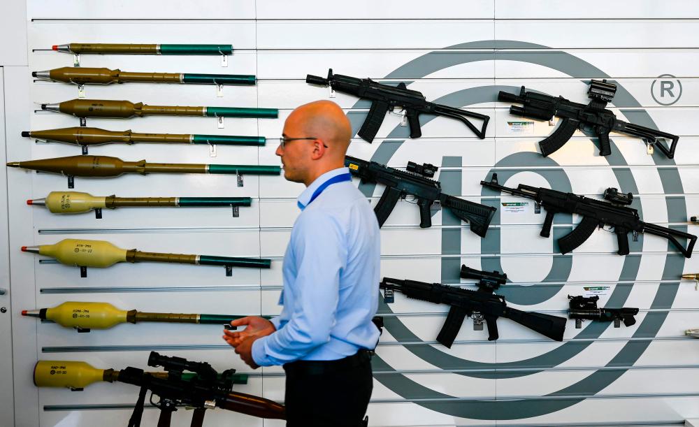 This picture taken on June 1, 2022, shows a man walking past RPG-7, RTB-7MA Thermobaric RPG and rifles at the Arsenal Kazanlak stand, during the 15th Defence Equipment and services Exhibition HEMUS-Defence, Anti-terrorism and Security in Plovdiv, Bulgaria. AFPPIX