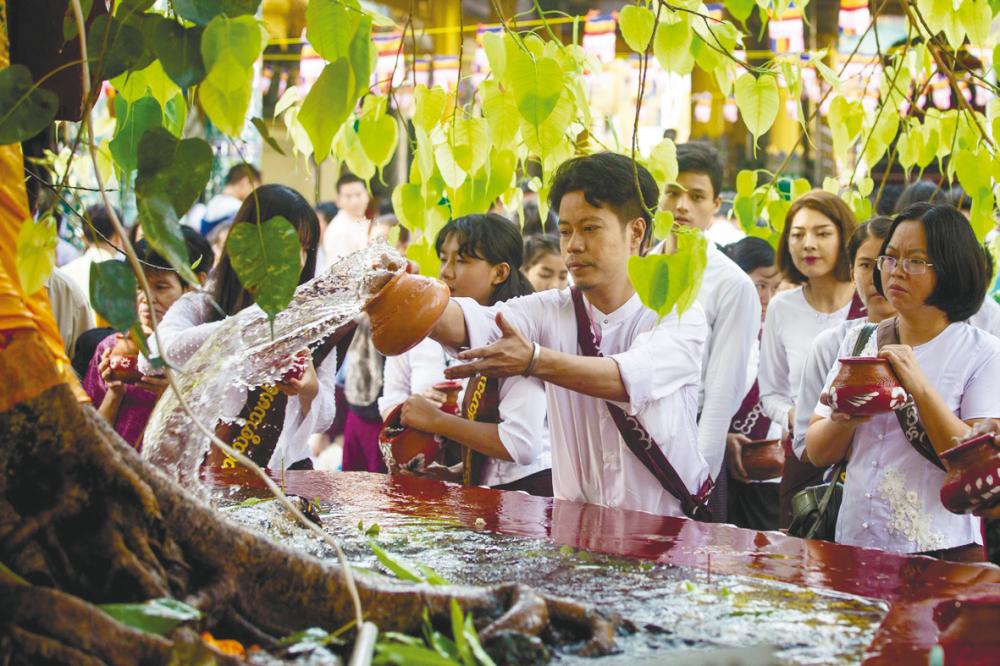 $!Buddhist devotees pour water on the Maha-Bodhi Tree at the Shwedagon Pagoda during Buddha’s birthday in Yangon, Myanmar.