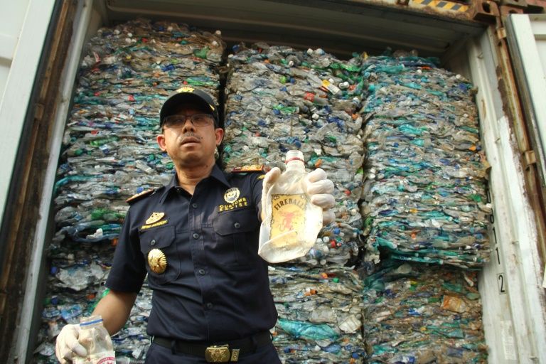 An Indonesian customs officer shows contaminated plastic waste from a container at Jakarta’s international seaport. — AFP