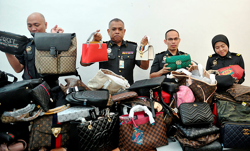 Johor’s Domestic Trade and Consumer Affairs Ministry enforcement chief Aris Mamat (C) showing members of the media the seized items. — Bernama