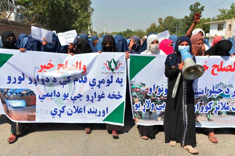 Afghan women hold banners and chant slogans in Jalalabad during a march to show their support for peace talks between Afghan government and the Taliban. — AFP